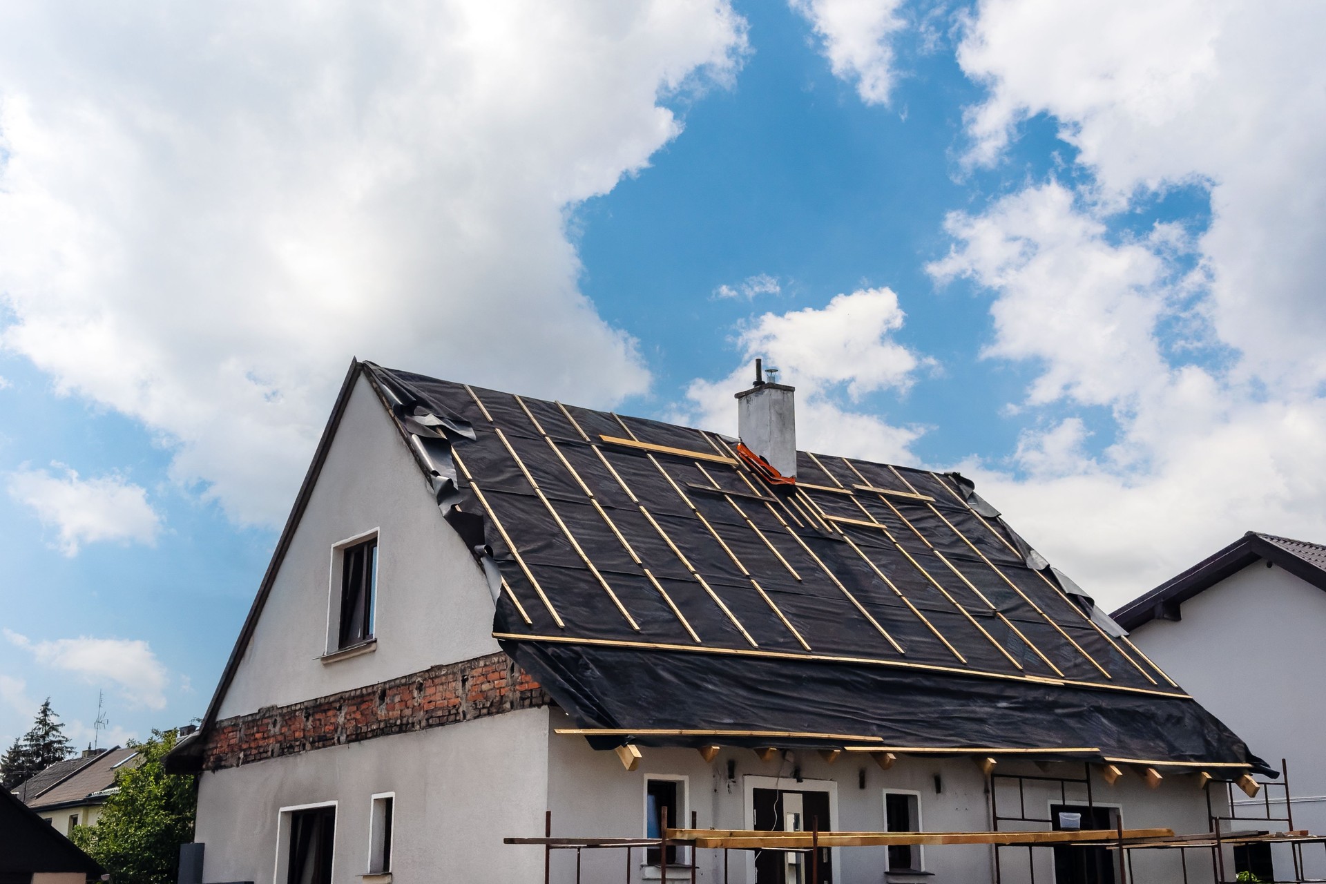 Roofing installation underway on a residential house under construction