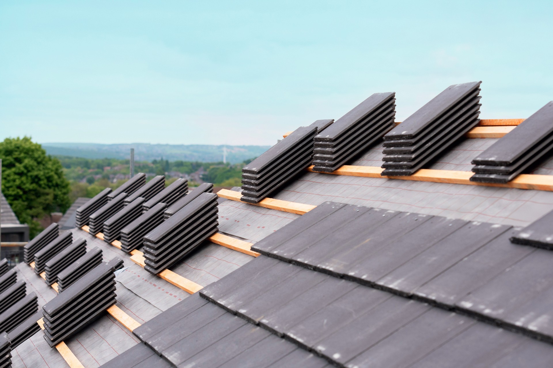 Roof tiles stacked and ready for installation on a residential building during overcast weather conditions